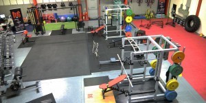 High view of gym showing olympic lifting platform, power cages, concept 2 rower, astroturf, prowler, sleds, tractor tyres, cables and weights